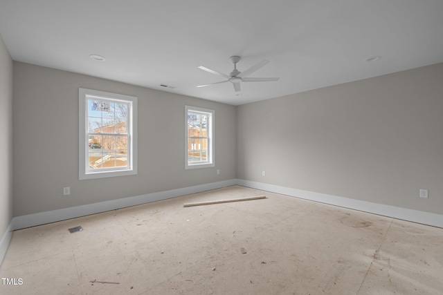 empty room featuring visible vents, a ceiling fan, and baseboards