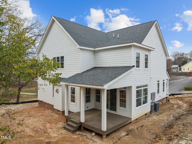 rear view of property featuring a deck, roof with shingles, and crawl space