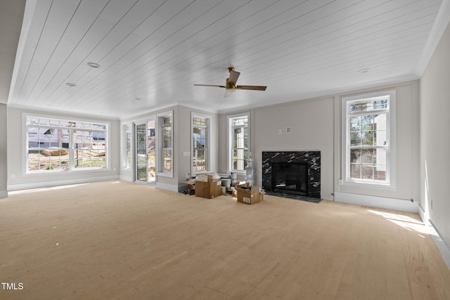 unfurnished living room featuring a high end fireplace, wooden ceiling, and wood finished floors