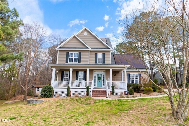 view of front of house featuring covered porch, a front yard, and roof mounted solar panels