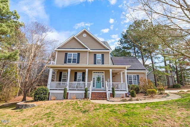 view of front of house featuring a front yard, covered porch, and roof mounted solar panels