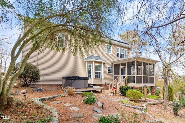 back of house featuring a sunroom and a hot tub