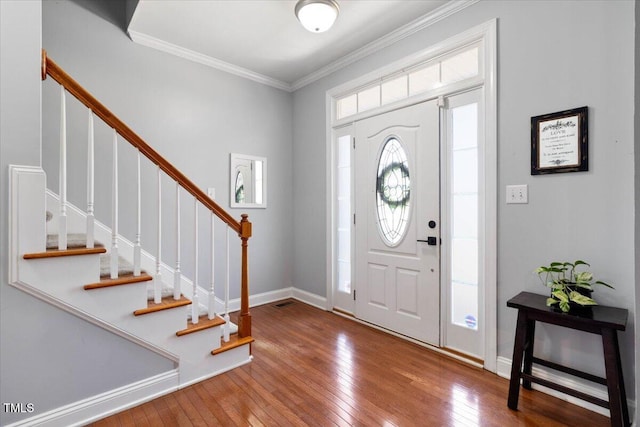 entrance foyer featuring ornamental molding, baseboards, stairway, and hardwood / wood-style floors