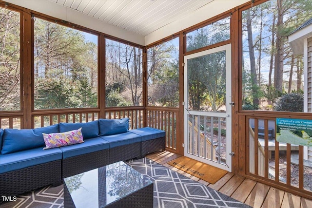 sunroom / solarium featuring wood ceiling and a healthy amount of sunlight