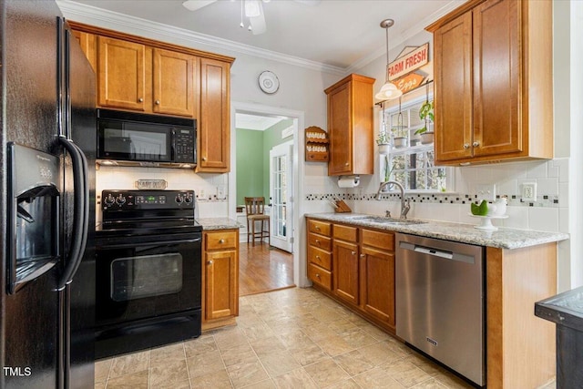 kitchen featuring brown cabinets, a sink, and black appliances