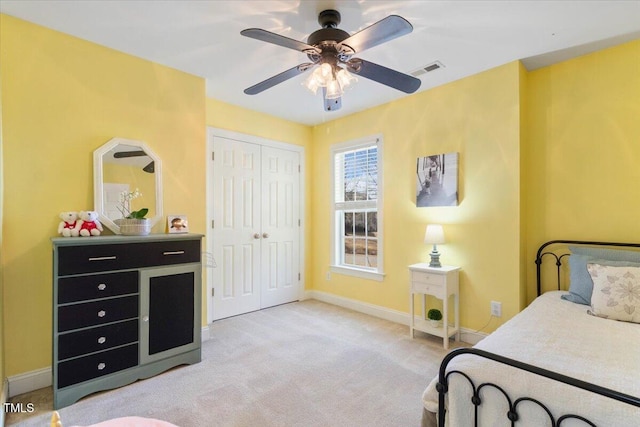 carpeted bedroom featuring a closet, visible vents, ceiling fan, and baseboards