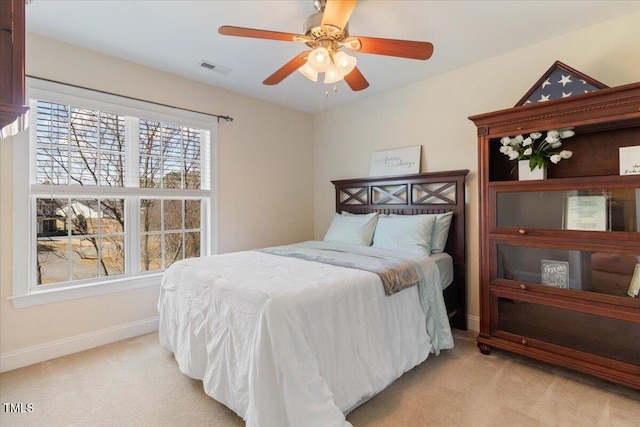 bedroom with baseboards, a ceiling fan, visible vents, and light colored carpet