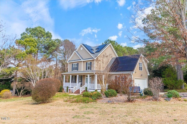 view of front of home with a garage, solar panels, a porch, and a front yard