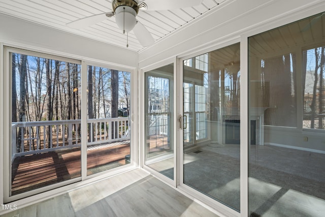 unfurnished sunroom with a ceiling fan