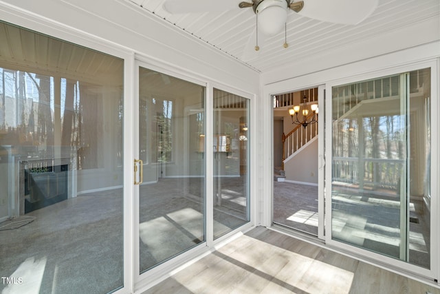 unfurnished sunroom with ceiling fan