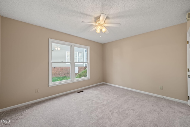 carpeted spare room with visible vents, baseboards, a textured ceiling, and ceiling fan