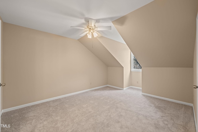 bonus room featuring a ceiling fan, vaulted ceiling, light colored carpet, and baseboards