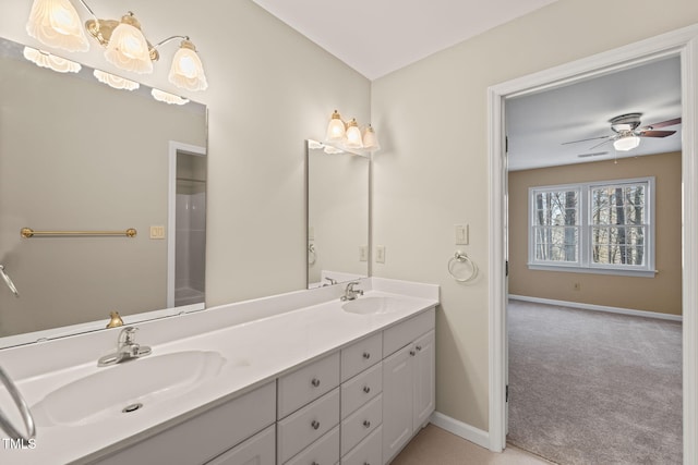 full bathroom with double vanity, ceiling fan, baseboards, and a sink