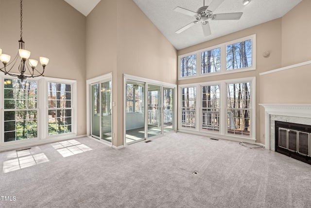 unfurnished sunroom featuring visible vents, ceiling fan with notable chandelier, a fireplace, and vaulted ceiling