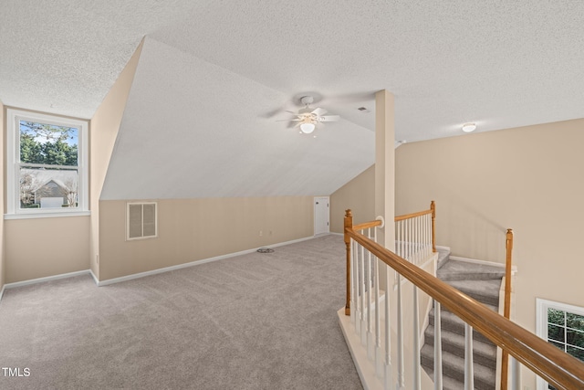 bonus room with vaulted ceiling, visible vents, carpet floors, and a textured ceiling