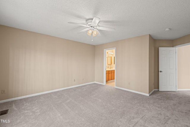 empty room with baseboards, visible vents, ceiling fan, a textured ceiling, and light carpet