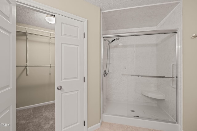 bathroom featuring a shower stall and a textured ceiling