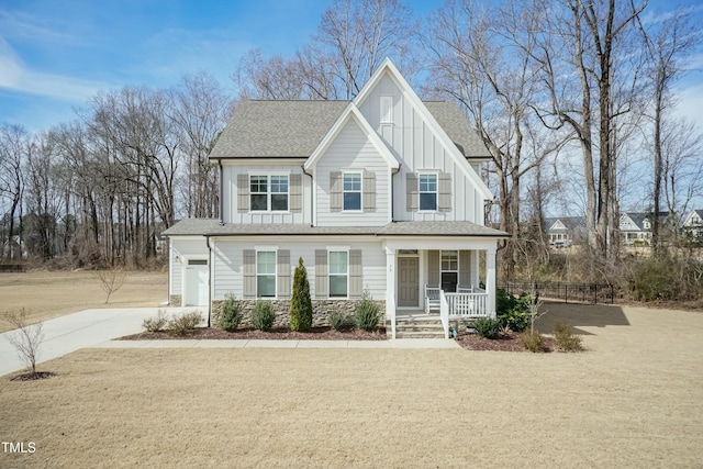 view of front of house featuring a garage, concrete driveway, stone siding, a porch, and board and batten siding