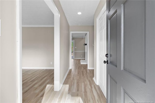 hall with baseboards and light wood-style floors