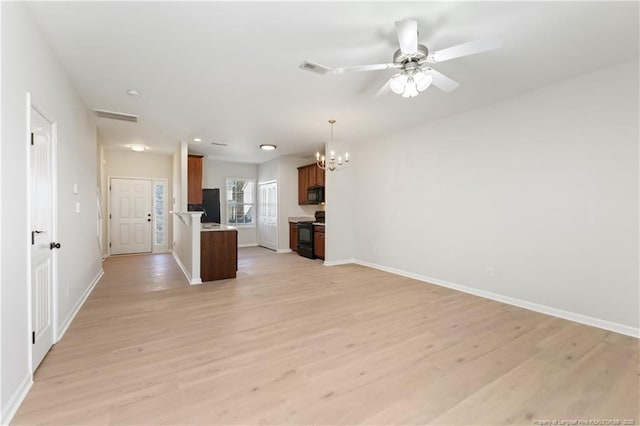 kitchen featuring black appliances, open floor plan, light wood-style floors, and light countertops