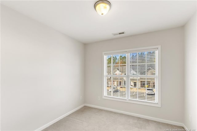 spare room with light carpet, baseboards, and visible vents