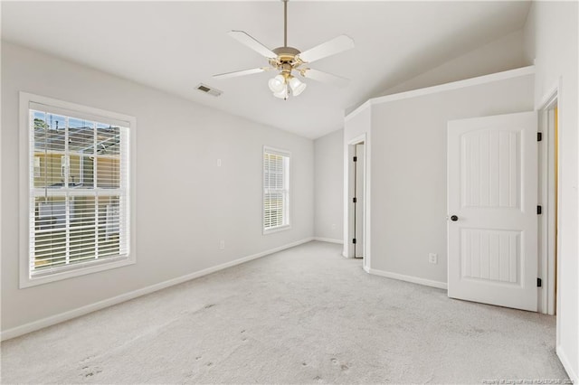 unfurnished bedroom featuring carpet flooring, a ceiling fan, visible vents, vaulted ceiling, and baseboards