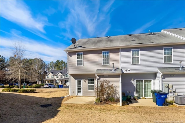 back of property with a yard, a patio, and central air condition unit