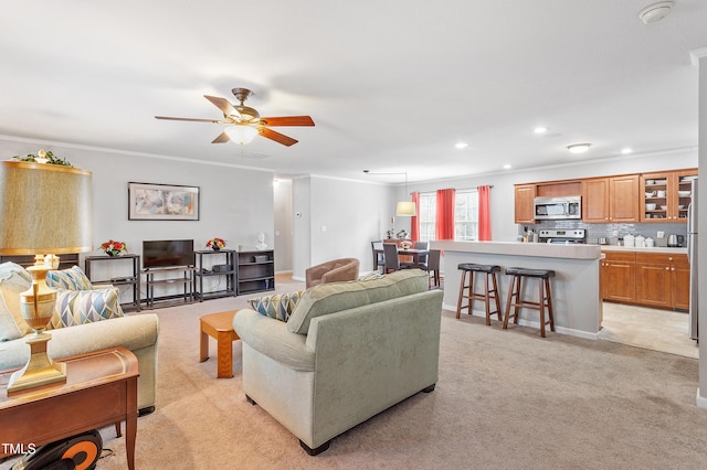 living room featuring recessed lighting, a ceiling fan, crown molding, and light colored carpet