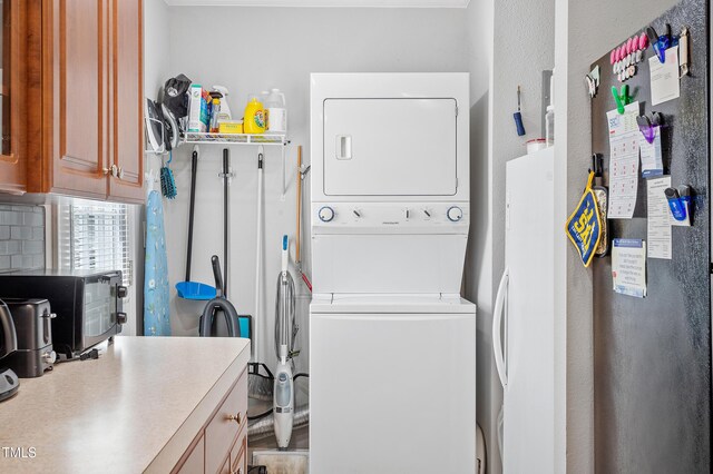 clothes washing area with laundry area and stacked washer / dryer