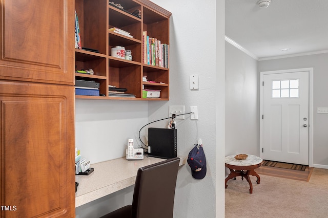 carpeted office space with ornamental molding and built in study area