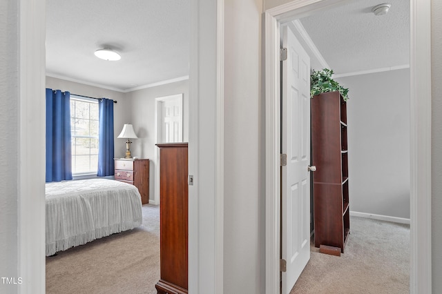 bedroom featuring a textured ceiling, ornamental molding, carpet flooring, and baseboards