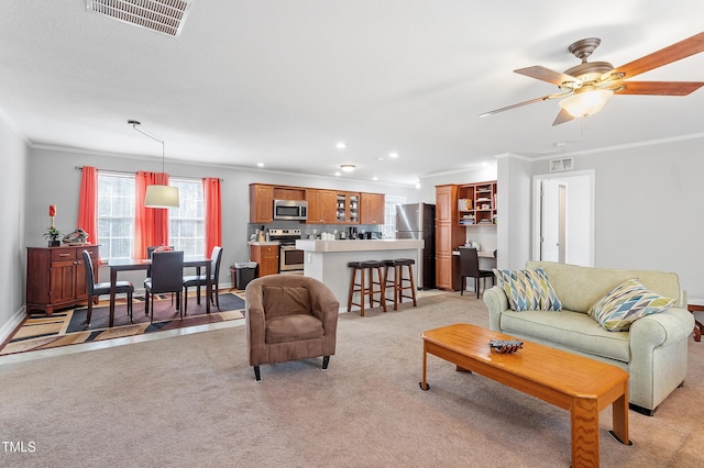 living room with recessed lighting, visible vents, crown molding, and light colored carpet