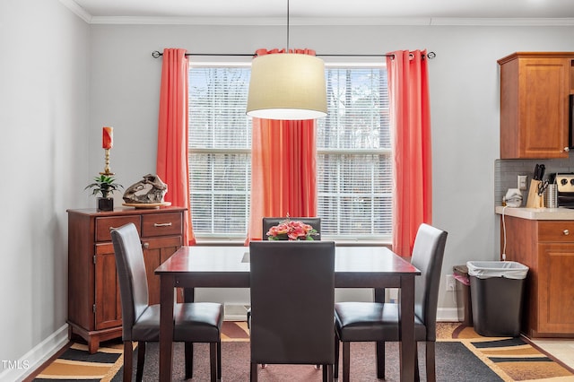 dining space featuring baseboards, plenty of natural light, and crown molding