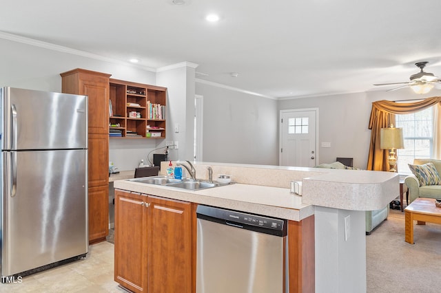 kitchen featuring stainless steel appliances, open floor plan, light countertops, and a sink