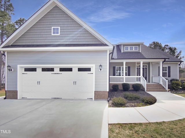 view of front facade with covered porch, concrete driveway, brick siding, and a garage