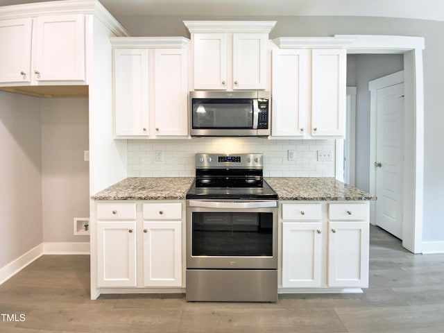 kitchen featuring appliances with stainless steel finishes, white cabinets, and tasteful backsplash