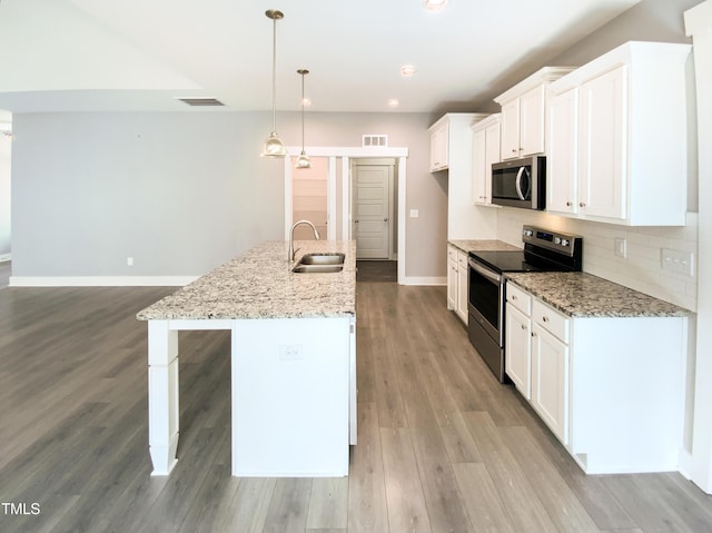 kitchen with visible vents, white cabinets, decorative backsplash, appliances with stainless steel finishes, and a sink