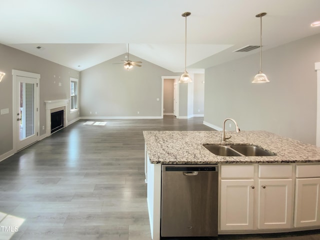 kitchen featuring a fireplace, visible vents, stainless steel dishwasher, open floor plan, and a sink