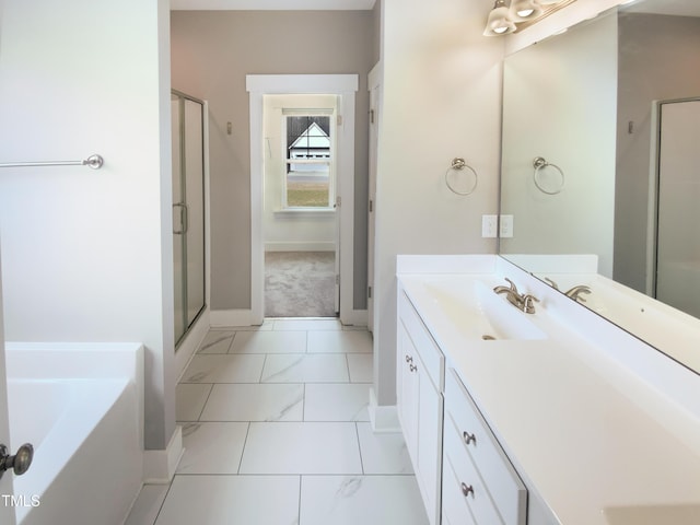 bathroom featuring a stall shower, baseboards, a garden tub, and vanity