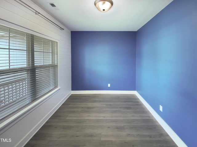 unfurnished room with visible vents, baseboards, and wood finished floors