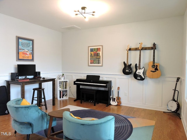 home office with a wainscoted wall and wood finished floors