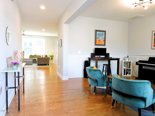 interior space with recessed lighting, a decorative wall, wainscoting, and light wood-style floors