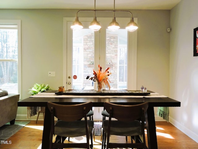 dining area with baseboards and wood finished floors