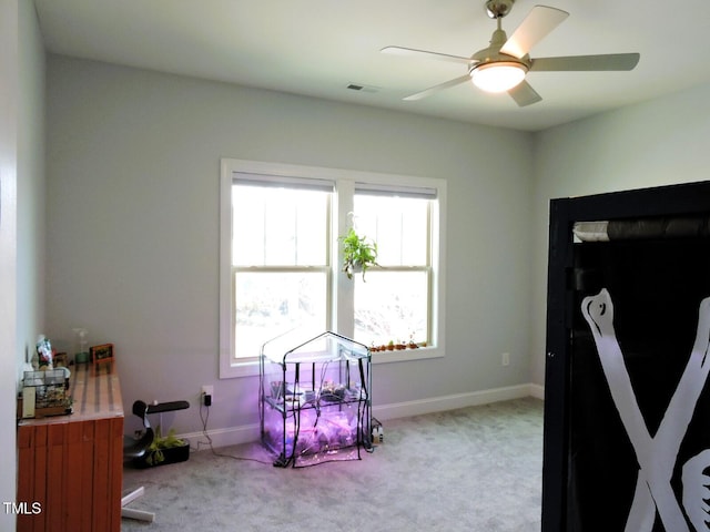 interior space featuring a ceiling fan, carpet, visible vents, and baseboards