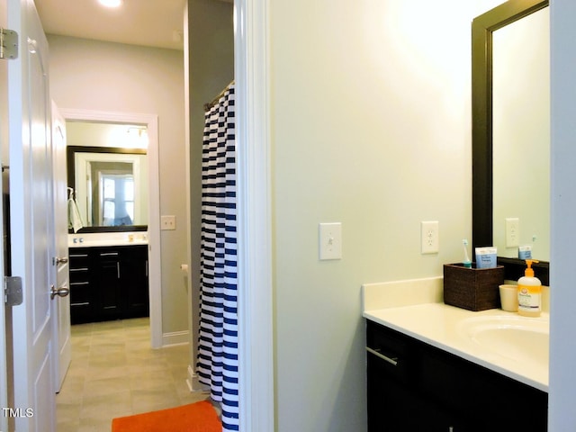 bathroom with curtained shower, tile patterned floors, and vanity