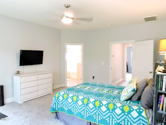 bedroom with light carpet, baseboards, visible vents, connected bathroom, and a ceiling fan