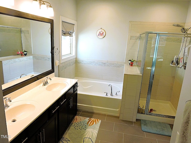 bathroom with double vanity, a stall shower, a sink, and a bath