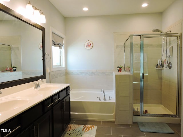 bathroom with a garden tub, tile patterned flooring, a sink, and a stall shower