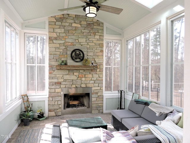 sunroom with a ceiling fan, a fireplace, and vaulted ceiling