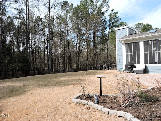 view of yard with a sunroom and fence